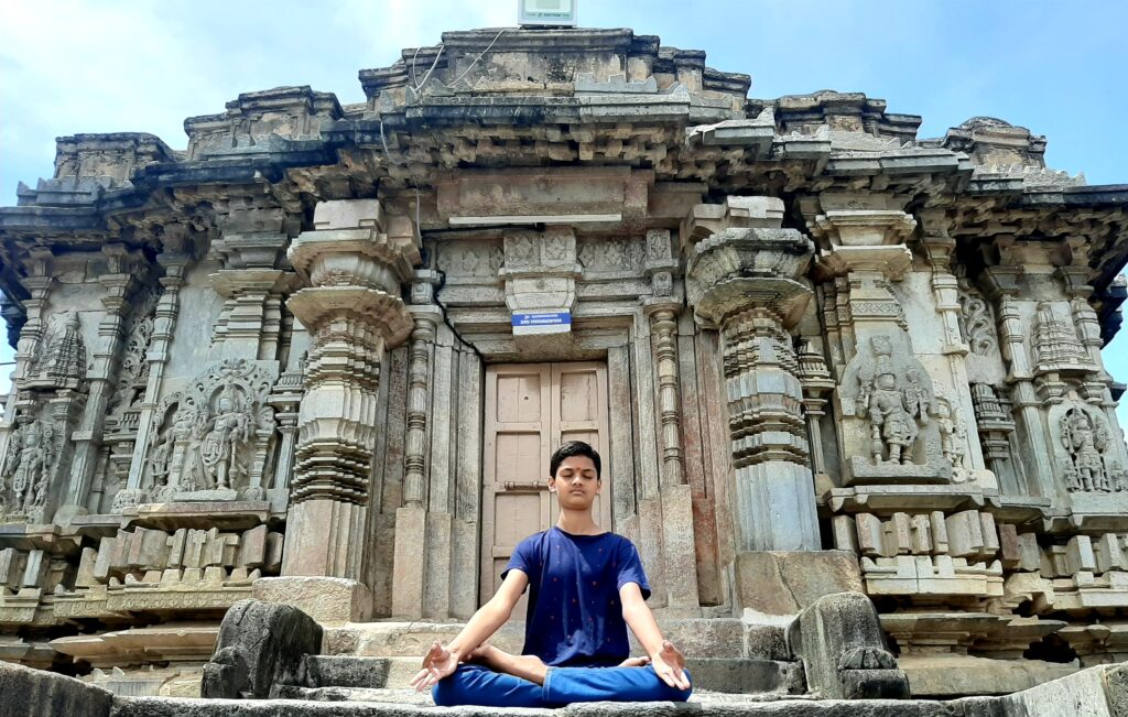 Young man meditating. Indian Temple